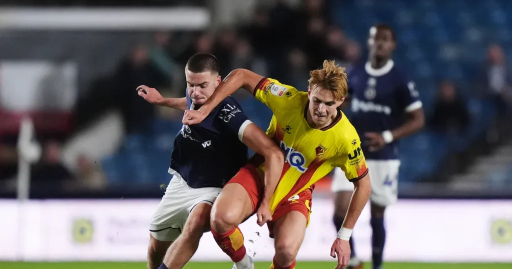 Millwall player struggle with Watford player for possession